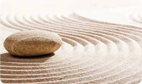 A rock sitting on top of sand in the middle of a circle.